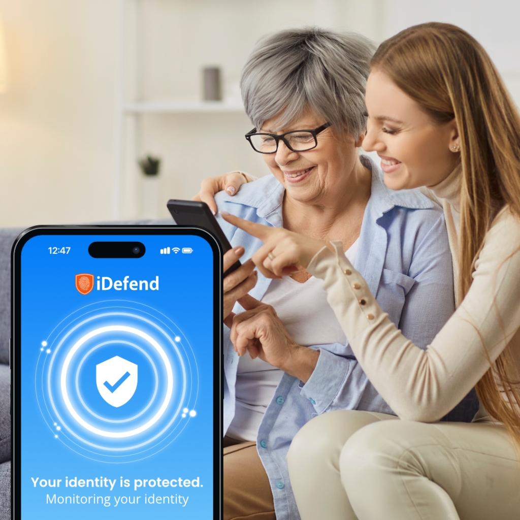 A senior woman using her phone, being assisted by adult daughter. Overlay of iDefend App protection.